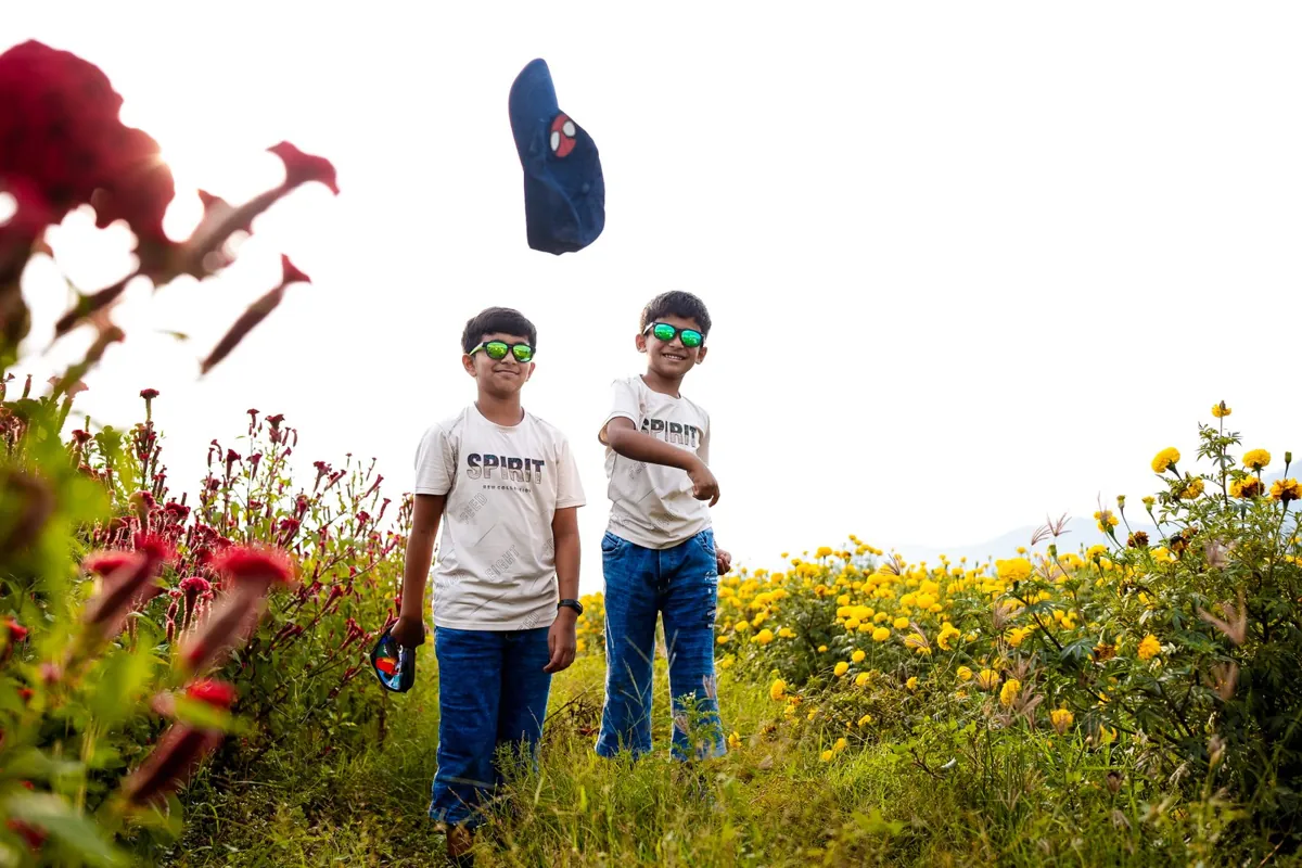 Two children standing among flowers