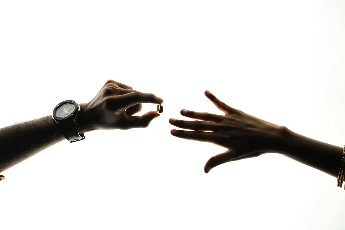 Two hands reaching towards one another in silhouette